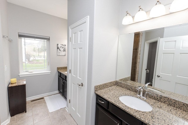 full bath with visible vents, tile patterned floors, baseboards, and vanity