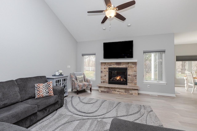 living area with visible vents, wood finished floors, a fireplace, and ceiling fan