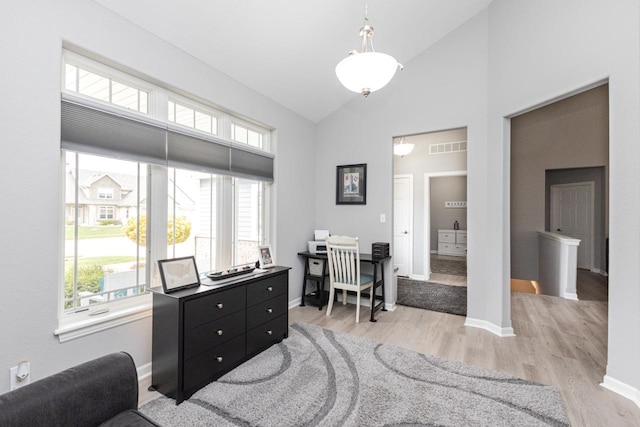 home office with baseboards, light wood-style flooring, visible vents, and high vaulted ceiling