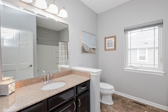 bathroom with baseboards, visible vents, toilet, and a wealth of natural light