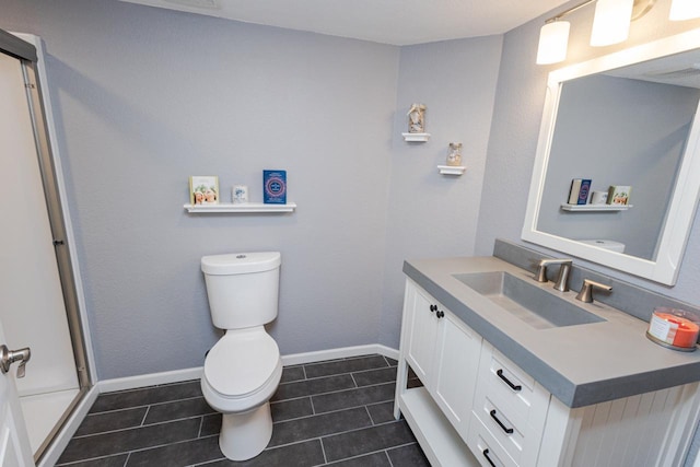 bathroom with baseboards, tile patterned floors, vanity, and toilet