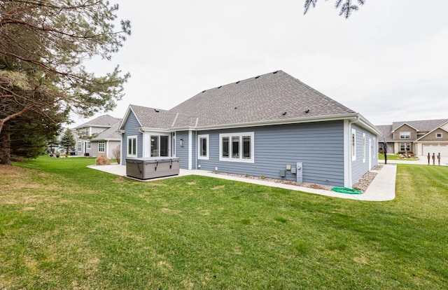 back of house with a patio area, a lawn, a hot tub, and roof with shingles