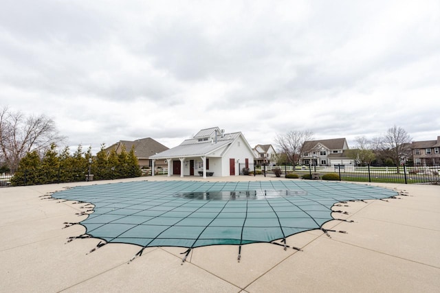 community pool with fence, a residential view, and a patio