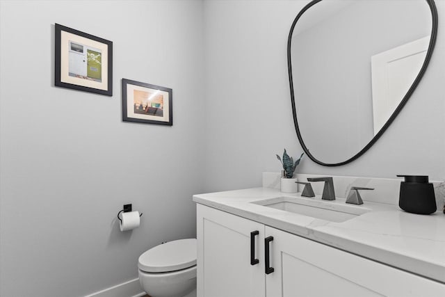 bathroom with vanity, baseboards, and toilet
