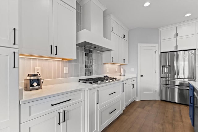 kitchen with recessed lighting, wall chimney exhaust hood, white cabinets, and stainless steel appliances
