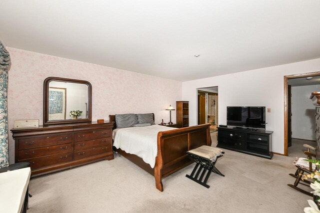 bedroom featuring wallpapered walls and light carpet