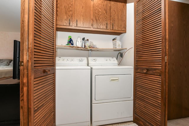 washroom featuring cabinet space and washing machine and clothes dryer