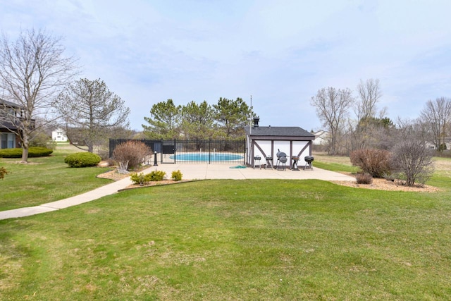 view of pool with a patio, fence, a fenced in pool, and a yard