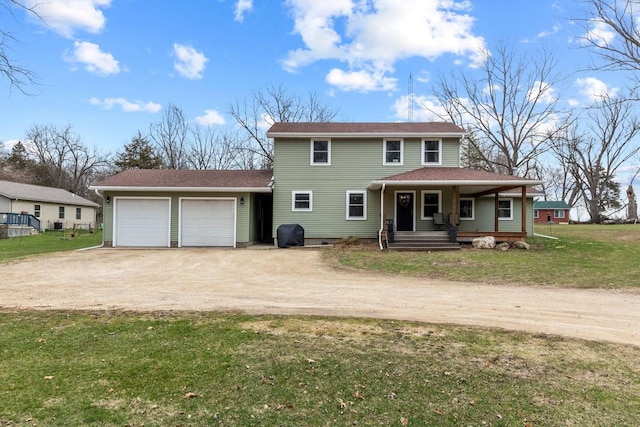 traditional-style home featuring a front lawn, driveway, covered porch, and a garage