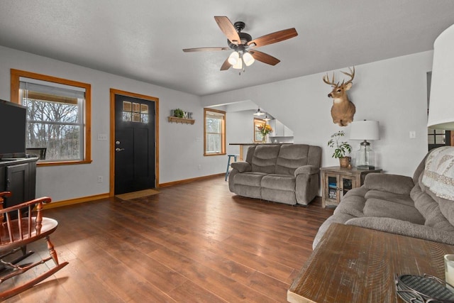 living area with wood finished floors, a wealth of natural light, and ceiling fan