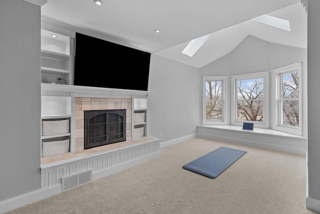 140 River Dr, Appleton, WI 54915 - unfurnished living room with lofted ceiling with skylight, carpet floors, a tiled fireplace, baseboards, and recessed lighting