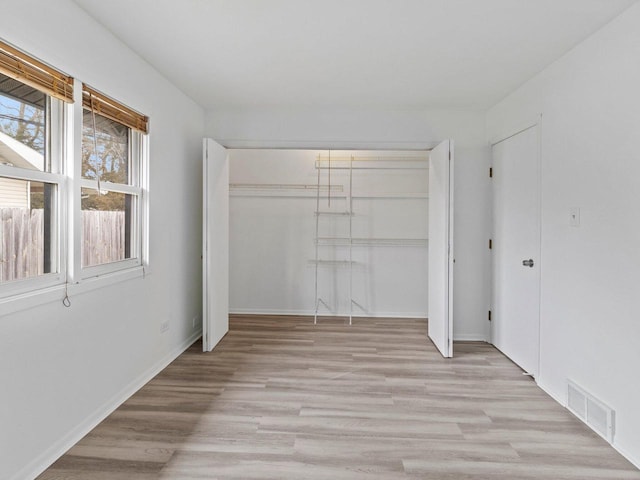 4155 Finch Ln, Delavan, WI 53115 - unfurnished bedroom featuring a closet, light wood-style flooring, visible vents, and baseboards