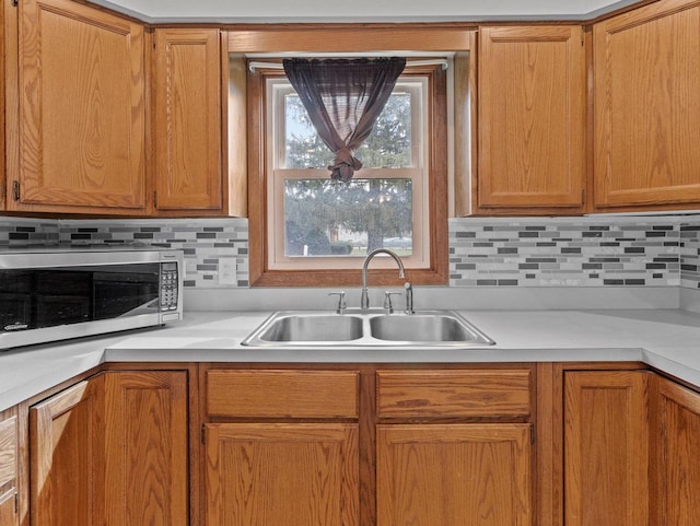 4155 Finch Ln, Delavan, WI 53115 - kitchen featuring light countertops, a sink, stainless steel microwave, and tasteful backsplash
