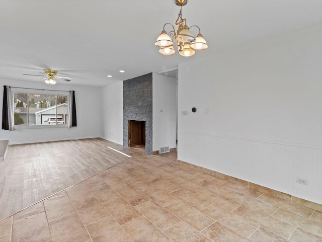 4155 Finch Ln, Delavan, WI 53115 - unfurnished living room with a stone fireplace, visible vents, and ceiling fan with notable chandelier