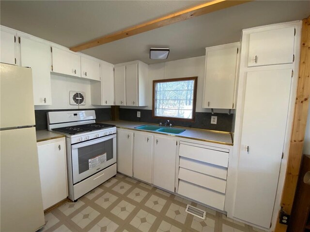 W8108 Vernon Ave, Trego, WI 54888 - kitchen featuring a sink, white appliances, light floors, white cabinets, and visible vents