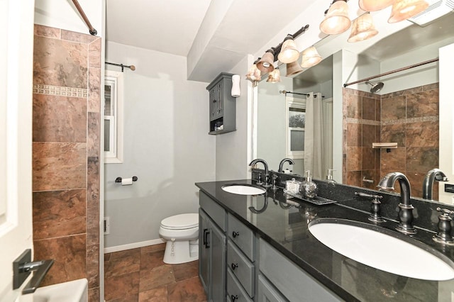 full bathroom with toilet, a sink, a shower, and double vanity