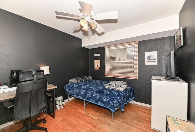 bedroom featuring ceiling fan, baseboards, and wood finished floors