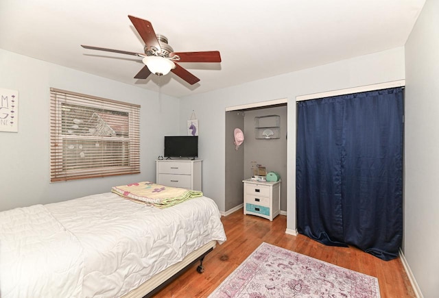 bedroom featuring baseboards, a ceiling fan, and wood finished floors
