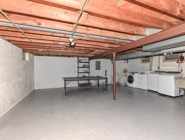 unfinished below grade area featuring electric panel and washer and clothes dryer