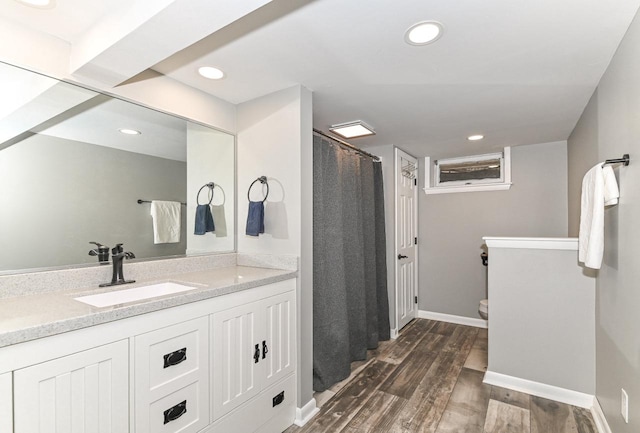bathroom featuring recessed lighting, wood finished floors, toilet, and vanity