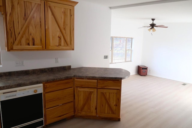 kitchen with dark countertops, light wood-type flooring, ceiling fan, a peninsula, and dishwashing machine