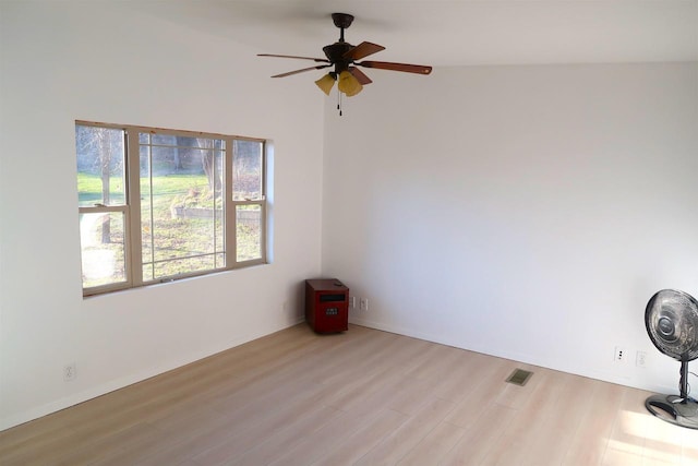 spare room featuring ceiling fan, wood finished floors, and visible vents