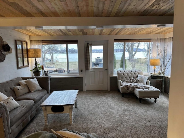 carpeted living room featuring wooden ceiling, beam ceiling, and a water view