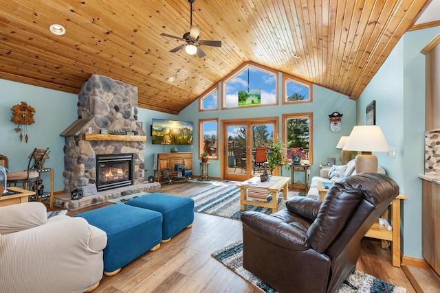 living room featuring hardwood / wood-style flooring, wooden ceiling, a stone fireplace, and ceiling fan