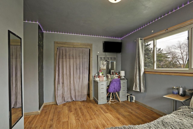 bedroom with baseboards and wood finished floors
