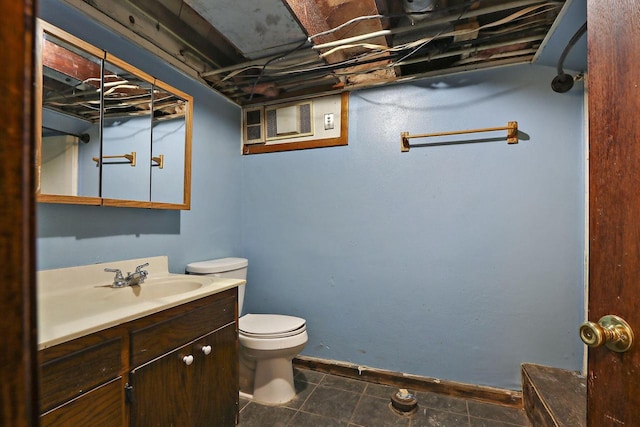 bathroom with toilet, vanity, and tile patterned floors