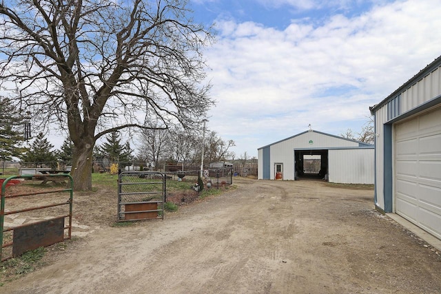 view of road with dirt driveway and an outbuilding