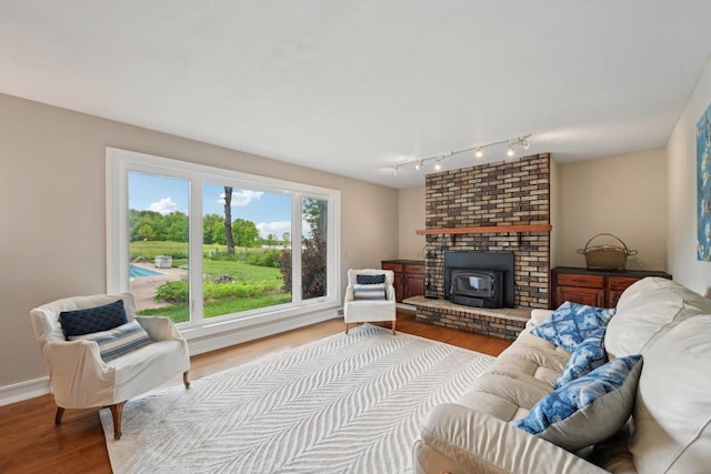 5407 Marsh Woods Dr, Mcfarland, WI 53558 - living area featuring wood finished floors, a wood stove, track lighting, and baseboards