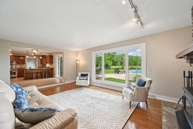 5407 Marsh Woods Dr, Mcfarland, WI 53558 - living area with light wood finished floors, baseboards, and track lighting