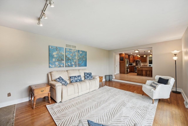 5407 Marsh Woods Dr, Mcfarland, WI 53558 - living area featuring light wood finished floors, baseboards, and rail lighting
