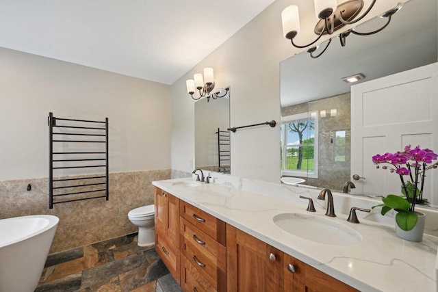 5407 Marsh Woods Dr, Mcfarland, WI 53558 - full bathroom featuring a chandelier, tile walls, a wainscoted wall, double vanity, and a towel warming rack
