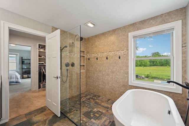 5407 Marsh Woods Dr, Mcfarland, WI 53558 - ensuite bathroom featuring walk in shower, a freestanding tub, tile walls, and stone finish floors