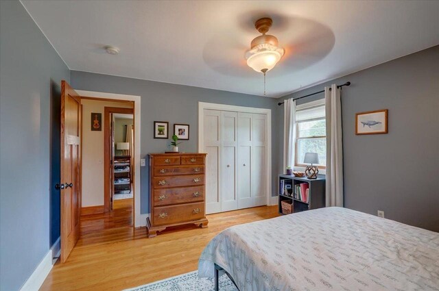 bedroom featuring baseboards, light wood-style floors, a closet, and ceiling fan