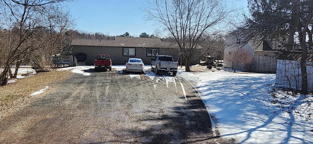 snow covered property featuring uncovered parking
