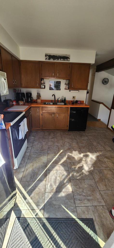 kitchen featuring range with electric stovetop, a sink, and white microwave