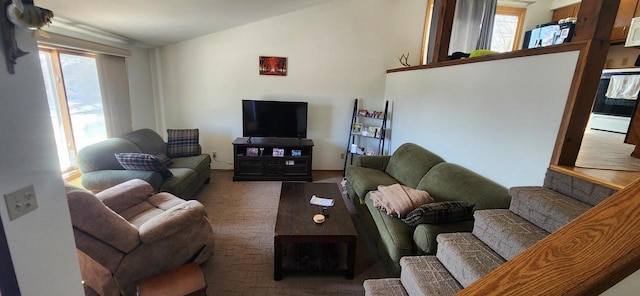 carpeted living area featuring a wealth of natural light and vaulted ceiling