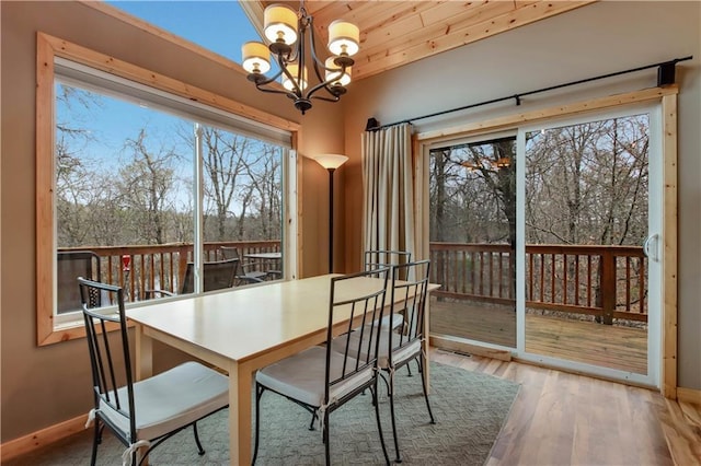 16187 Secluded Ln, Gordon, WI 54838 - dining space featuring baseboards, a healthy amount of sunlight, wood finished floors, and a chandelier