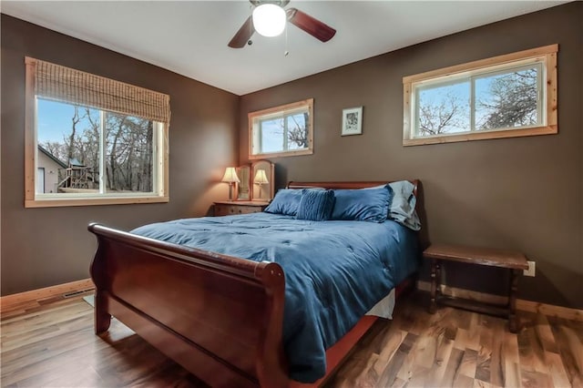 16187 Secluded Ln, Gordon, WI 54838 - bedroom with wood finished floors, a ceiling fan, baseboards, and multiple windows