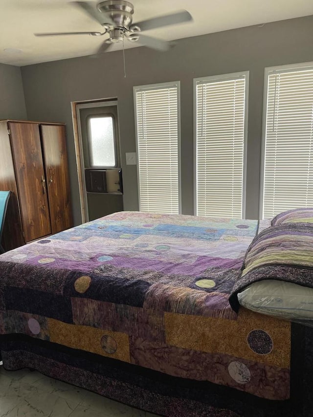 bedroom with marble finish floor and ceiling fan