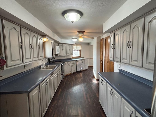 18196 200th St, Jim Falls, WI 54748 - kitchen with dark countertops, a ceiling fan, a sink, dark wood-type flooring, and appliances with stainless steel finishes