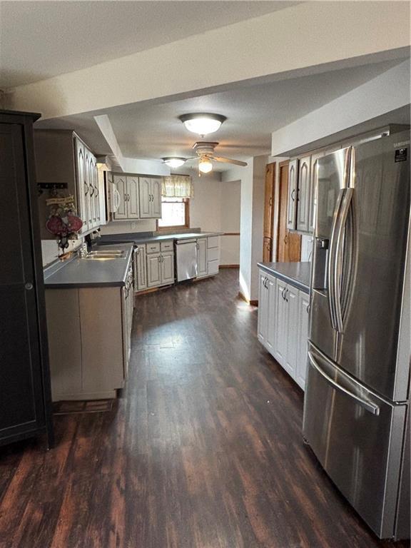 18196 200th St, Jim Falls, WI 54748 - kitchen featuring a sink, dark wood-style flooring, dark countertops, baseboards, and appliances with stainless steel finishes