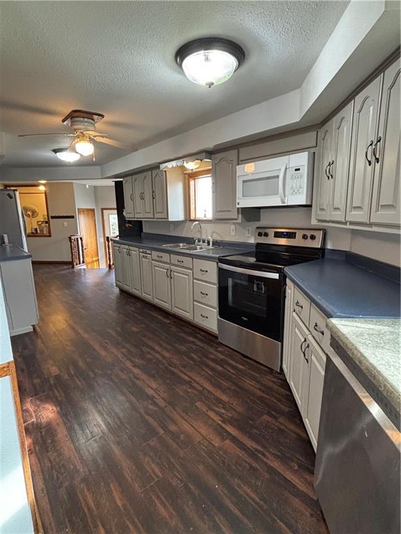 18196 200th St, Jim Falls, WI 54748 - kitchen featuring dark wood-style flooring, appliances with stainless steel finishes, a textured ceiling, and a sink