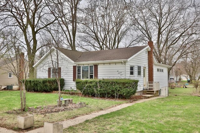 203 S Main St, Deerfield, WI 53531 - view of front facade with a chimney and a front lawn