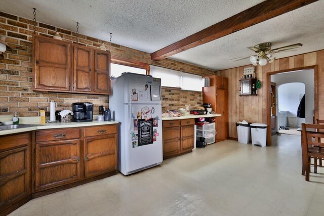203 S Main St, Deerfield, WI 53531 - kitchen featuring a textured ceiling, brown cabinets, light floors, light countertops, and freestanding refrigerator