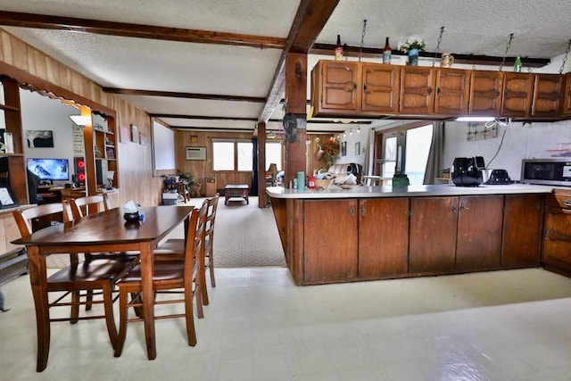 203 S Main St, Deerfield, WI 53531 - kitchen featuring light countertops, beam ceiling, a textured ceiling, stainless steel microwave, and wooden walls