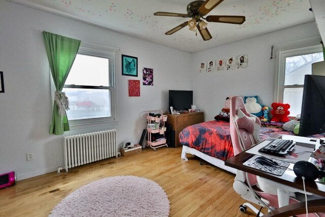 203 S Main St, Deerfield, WI 53531 - bedroom with radiator heating unit, wood finished floors, a ceiling fan, and multiple windows